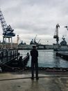 Man Standing and Facing Boats on Water