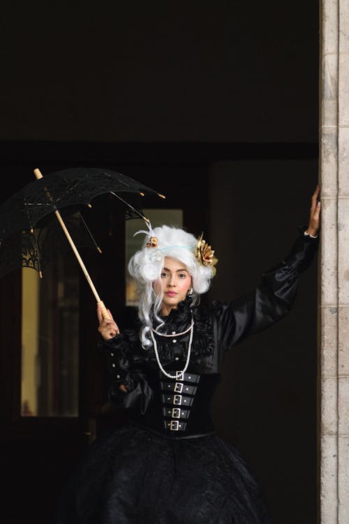 A woman in black and white costume holding an umbrella