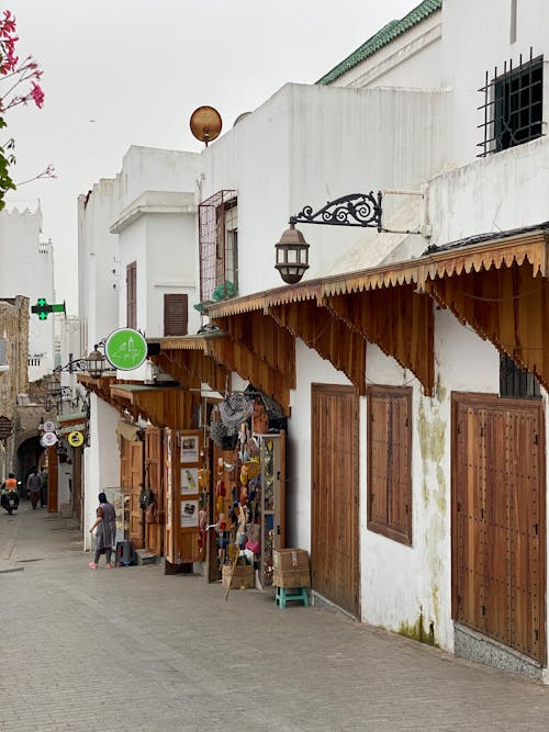 A narrow street with shops and people walking