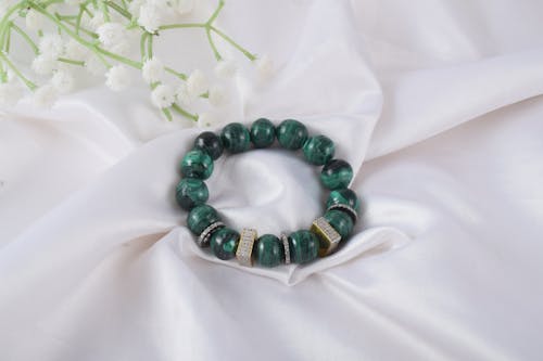 A green bracelet with a gold clasp