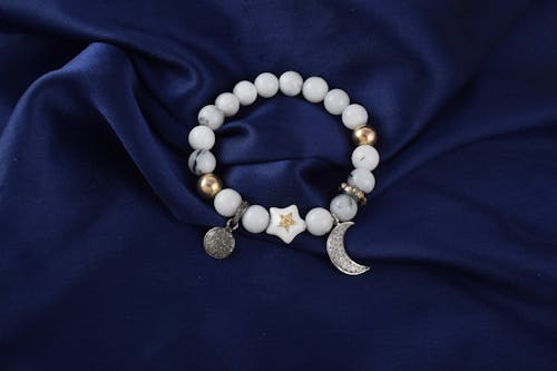 A white bracelet with a moon and star charm