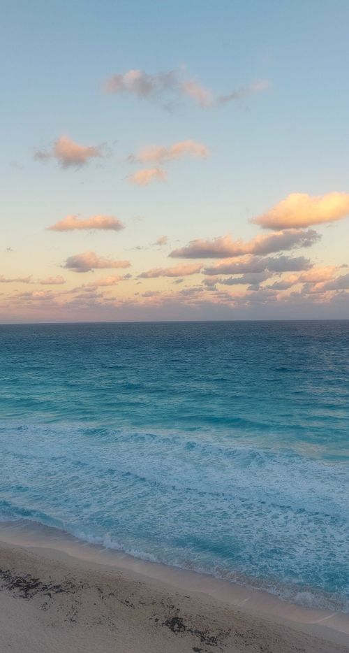 Free A tranquil view of the Cancún beach with gentle ocean waves at twilight, perfect for relaxation. Stock Photo