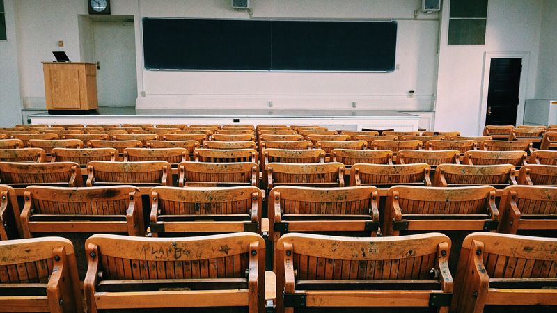 Empty lecture hall with rows of wooden seats