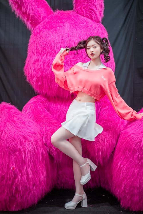 A woman posing in front of a giant pink bunny