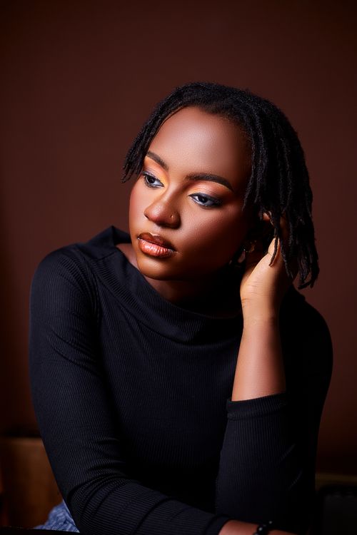 Free Stunning studio portrait of a contemplative woman with dreadlocks, highlighting natural beauty and elegance. Stock Photo