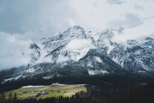 A snowy mountain range with a small village in the foreground