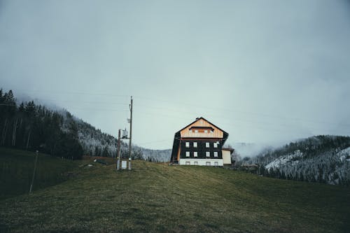 A house on a hill in the middle of a field