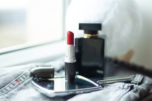 A lipstick and a pair of sunglasses on a table