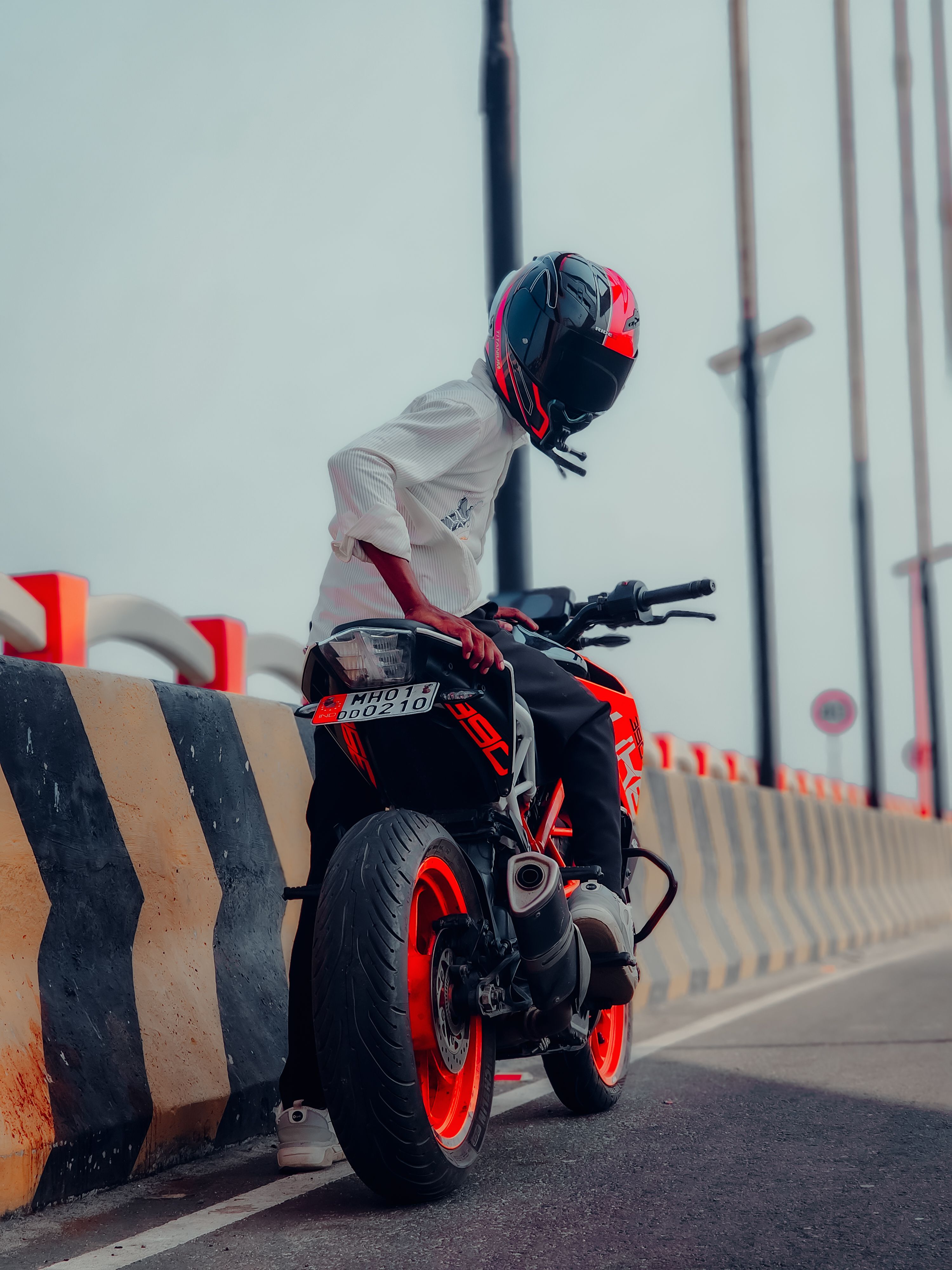 Motorcyclist in helmet on vibrant bike along urban highway in India.