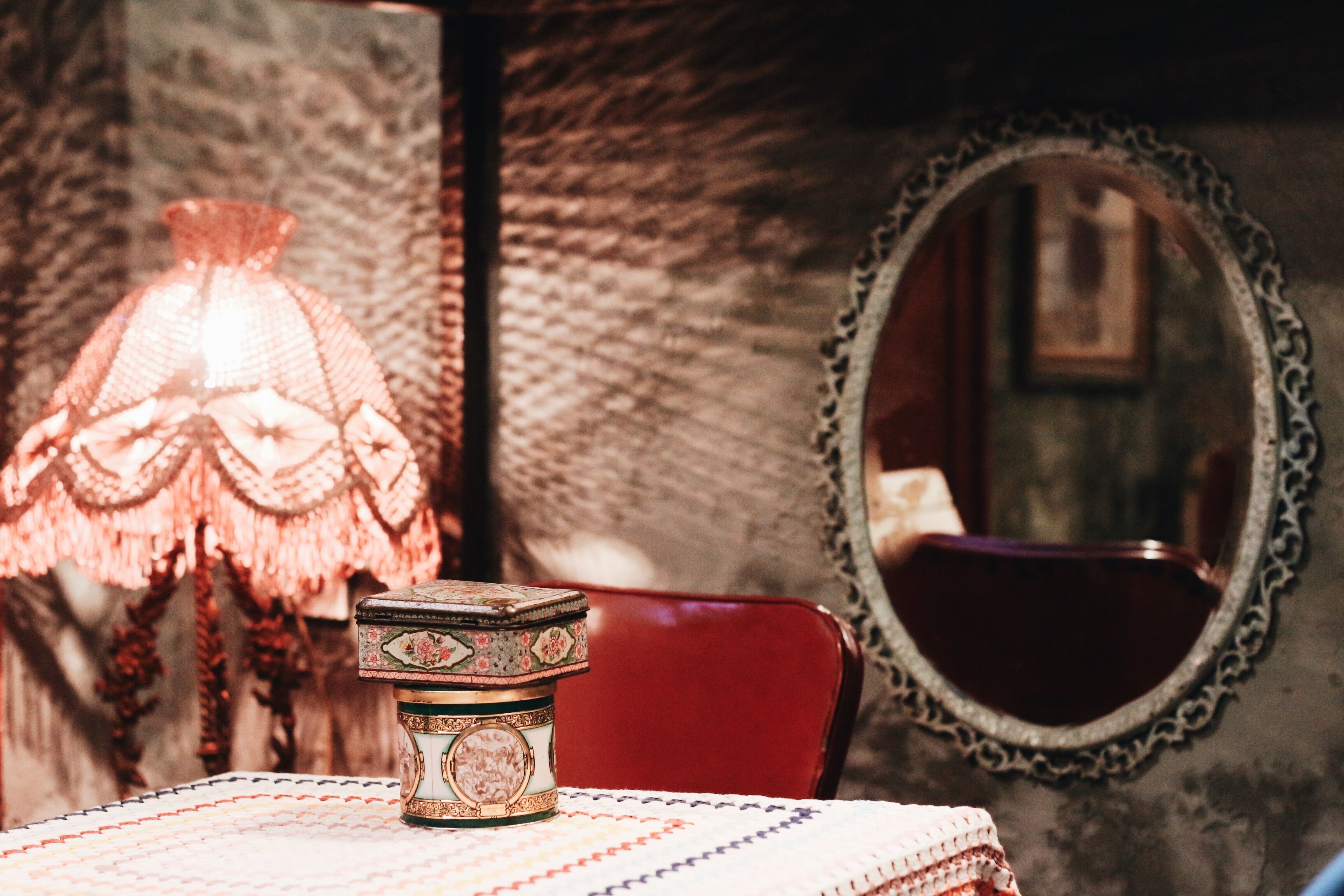 A cozy vintage setting with a decorative mirror and an ornate lamp casting warm light.