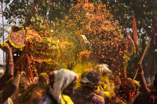 Free Vivid scene of people celebrating Holi with colorful powders in a festive outdoor environment. Stock Photo