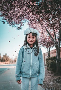 一个开朗的女孩戴着花冠，在户外欣赏春天的花朵