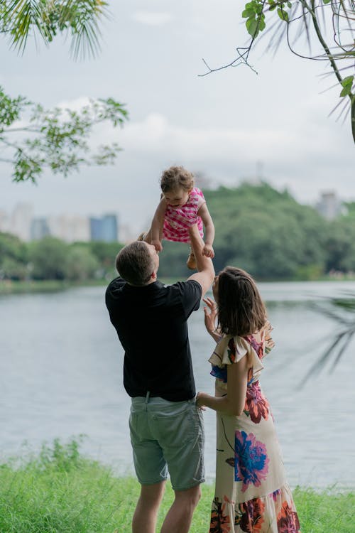 A family is standing in front of a lake