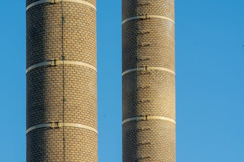 Two chimneys with smoke coming out of them