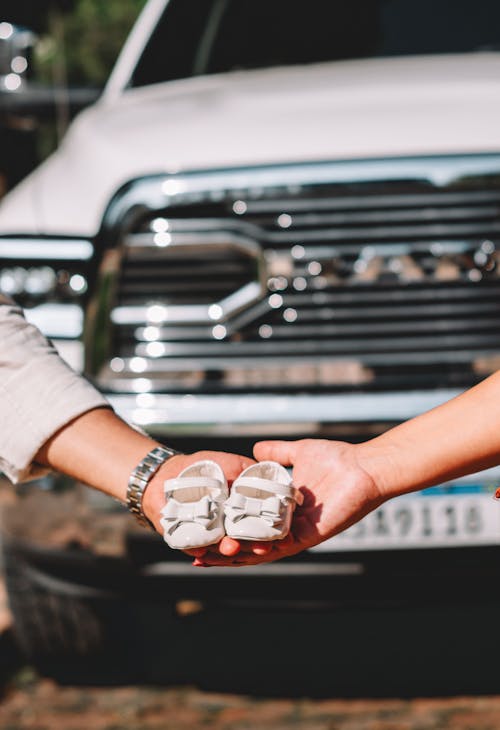 A man and woman holding a box of food in front of a truck