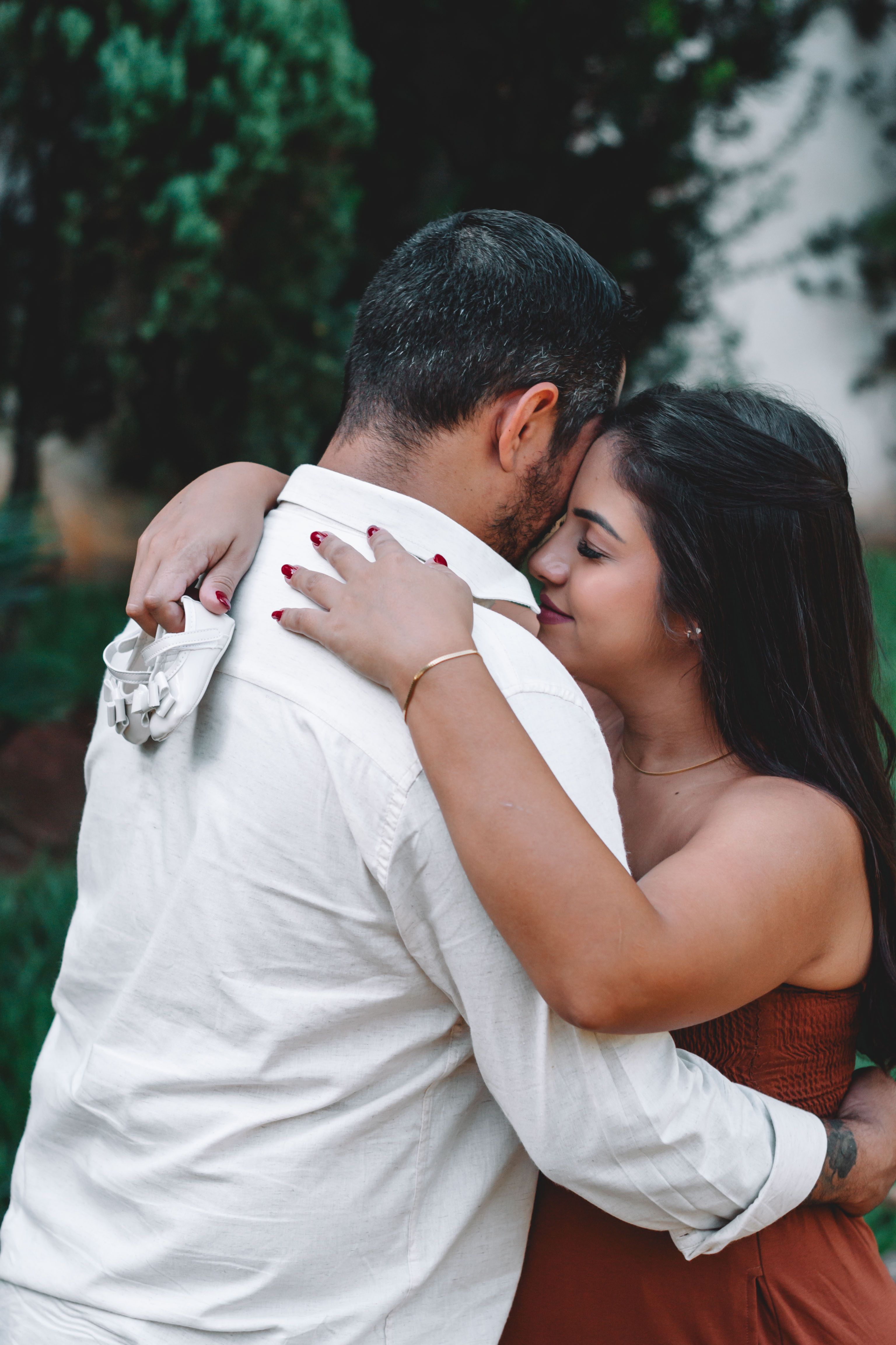 Couple Hugging and Holding Baby Shoes · Free Stock Photo