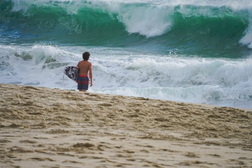 A person walking on the beach with a surfboard