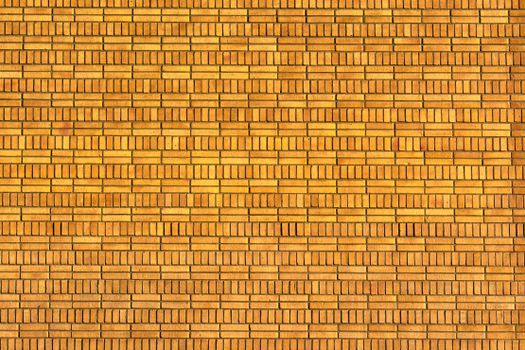 Close-up of a yellow brick wall showcasing intricate pattern and texture.
