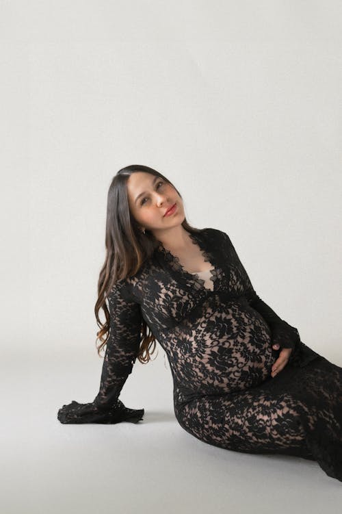 A pregnant woman in a black lace dress