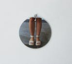 Reflection of Girl Feet in Sandals in Round Mirror on White Wall