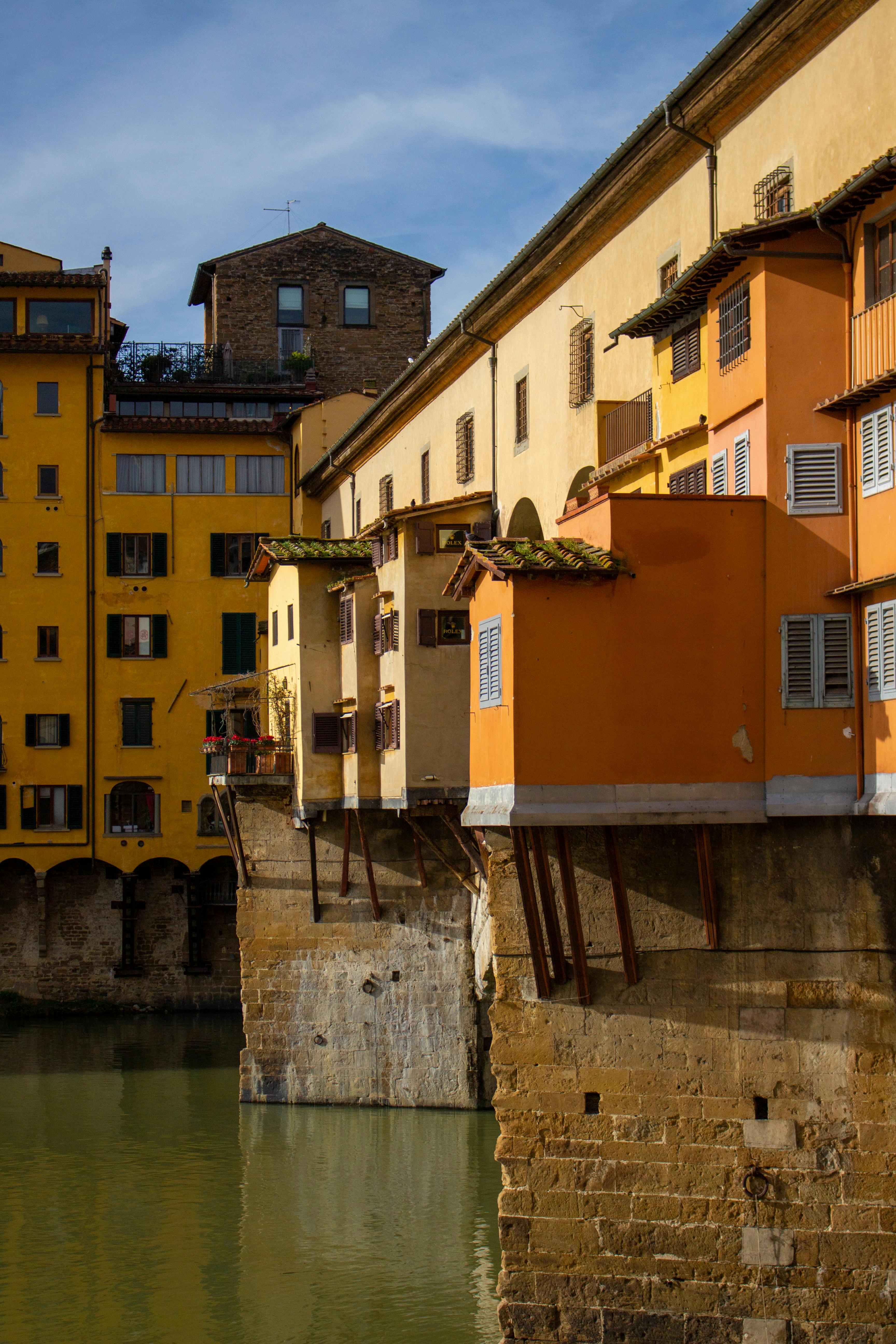A stunning view of Ponte Vecchio's colorful architecture in Florence, Italy, bathed in sunlight.