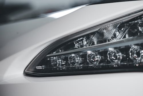 A close up of the headlights of a white car