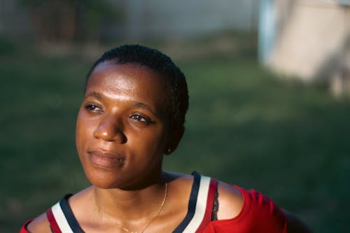 A woman in a red shirt and black shorts