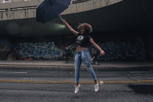 Woman Jumping and Holding Umbrella