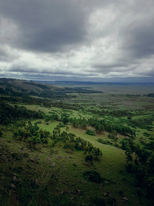A view of a green landscape with clouds