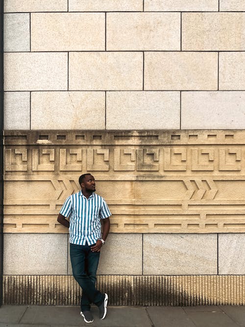 A man standing in front of a wall with a pattern
