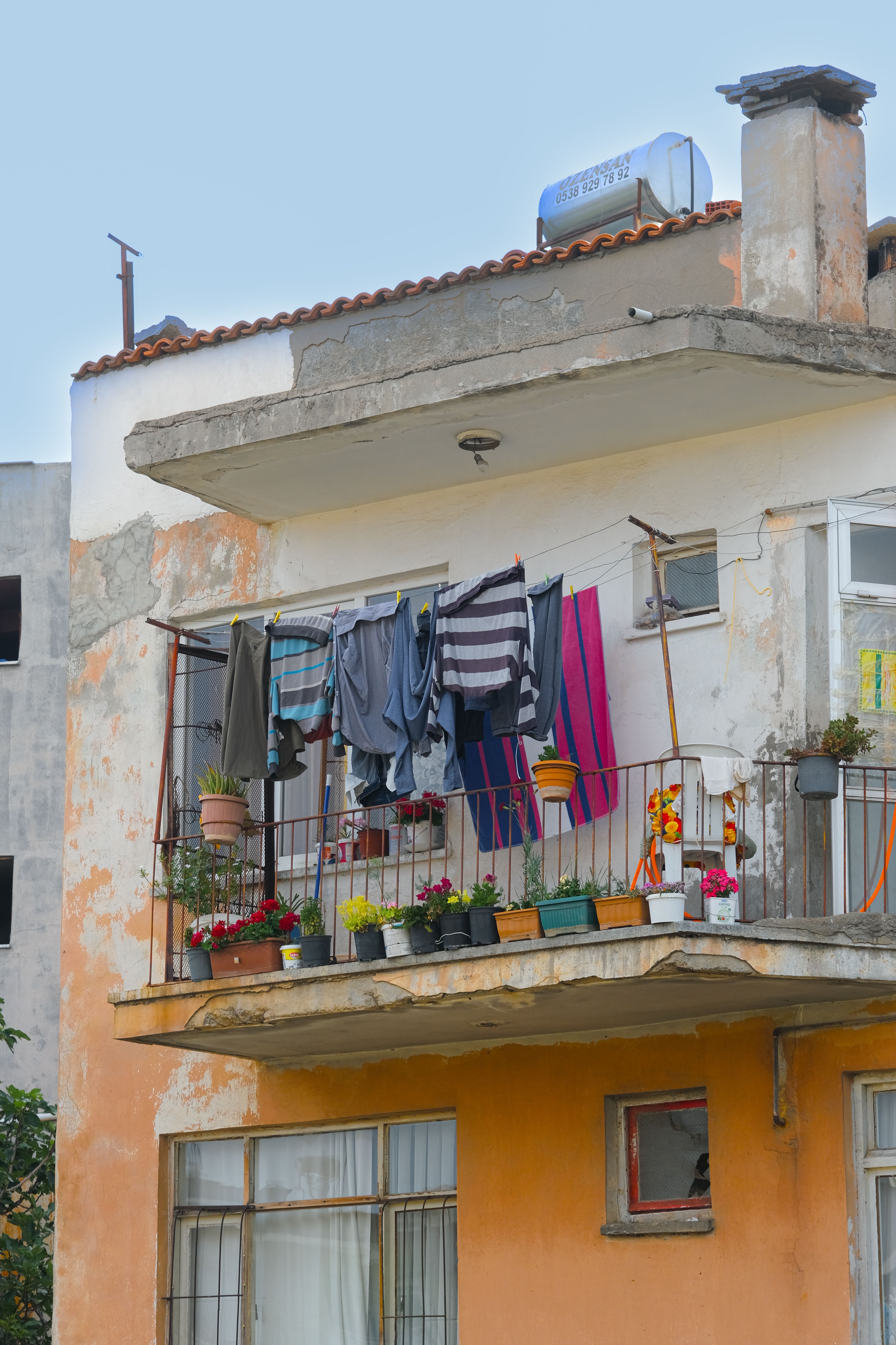 Retractable clothesline pulled out on a small apartment patio, holding a few small hung items