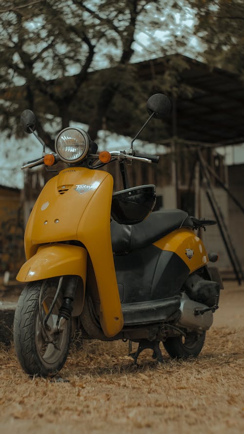 A yellow scooter parked in front of a building