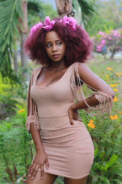 Woman With Burgundy Curly Hair Wearing Beige Sleeveless Tasseled Bodycon Dress