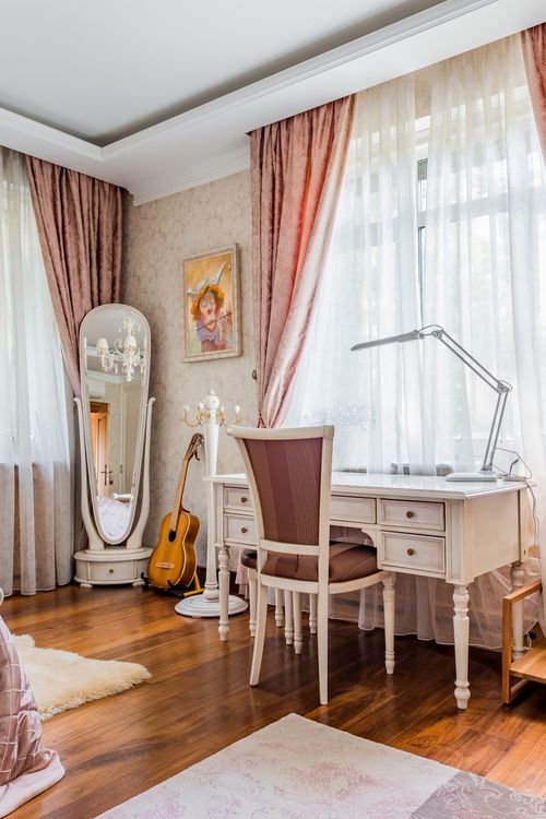 Free Stylish room featuring a vintage desk, guitar, and ornate mirror with soft natural lighting. Stock Photo