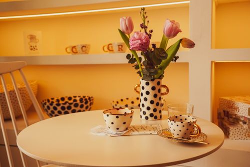 Free A cozy coffee table setting in Zagreb with polka dot cups and fresh tulips in a stylish interior. Stock Photo