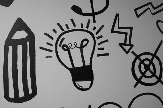 Close-up of abstract doodles featuring a light bulb in black ink on a white background.