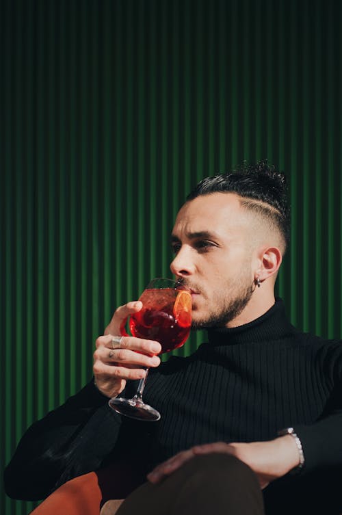 Man in a Black Turtleneck Drinking a Cocktail 