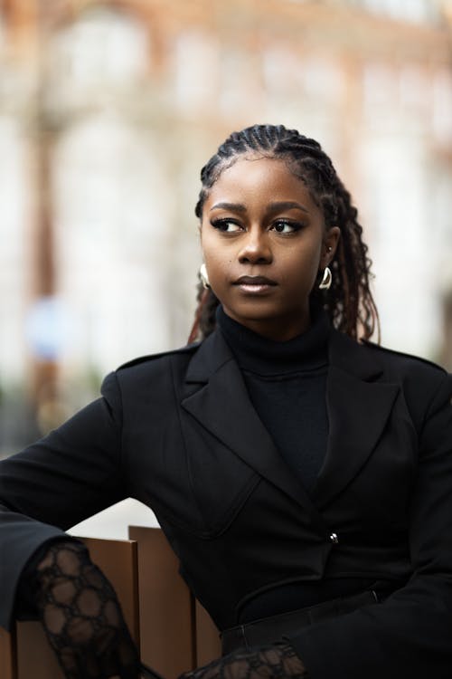 A woman in a black suit sitting on a bench