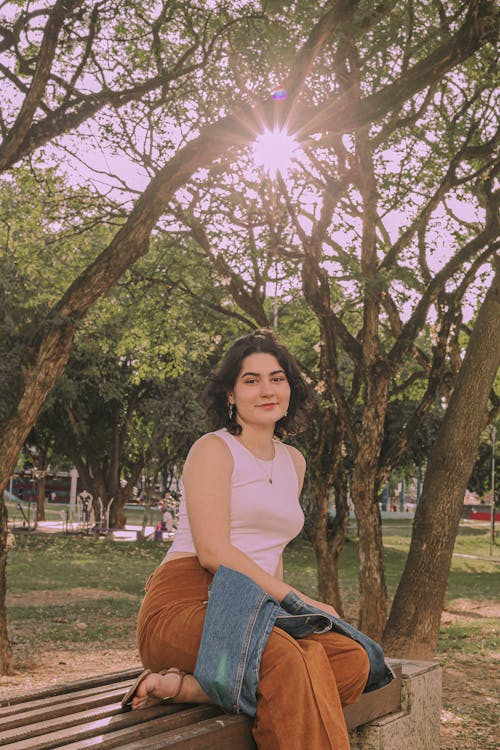 A woman sitting on a bench in a park