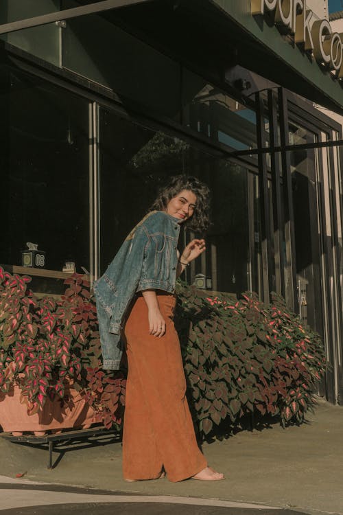 A woman in a brown jumpsuit and denim jacket