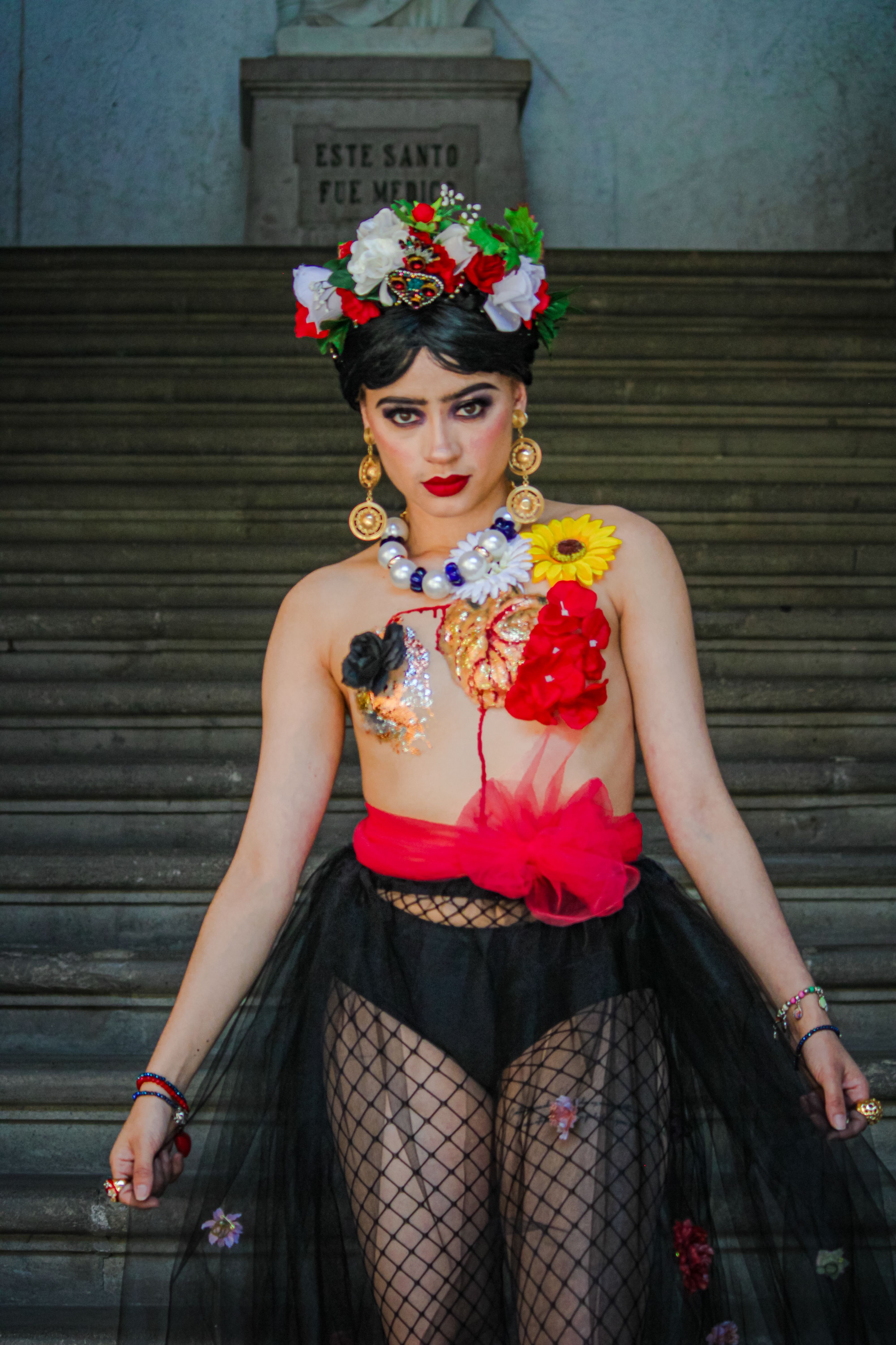 Stylish portrait of a woman with a floral wreath standing confidently on stone stairs in Mexico City.