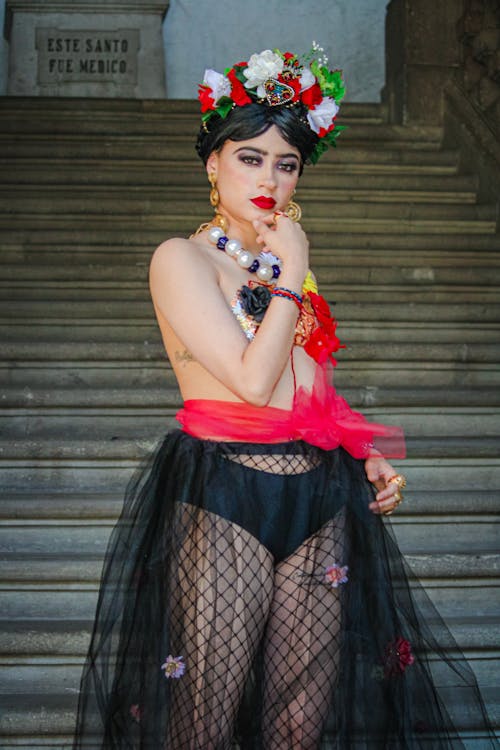 A woman in a black and red outfit posing on steps