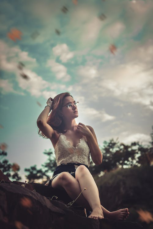 Woman Sitting on Ground While Holding Her Hair