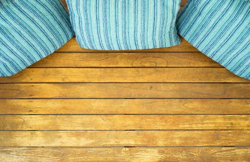 Free Top view of striped cushions on a wooden floor, creating a cozy home decor setting. Stock Photo