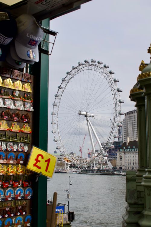 Free View of London Eye with nearby souvenir shop by River Thames, showcasing urban landmarks. Stock Photo
