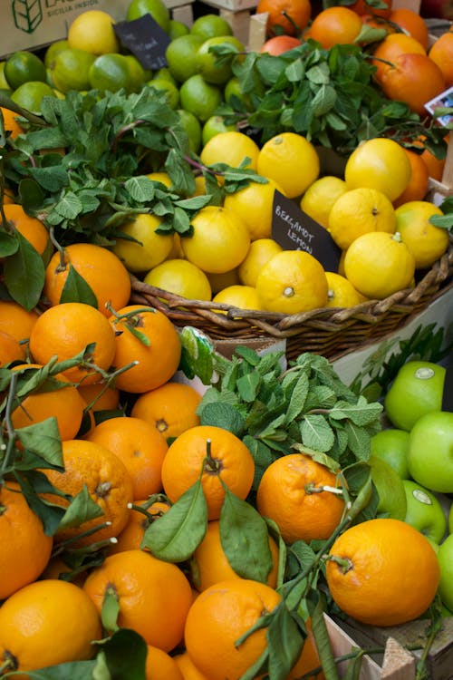 A bunch of oranges and lemons sitting in a basket