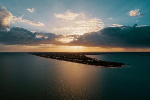 日落时分，从空中俯瞰岛屿，壮观的云层与宁静的海洋构成令人惊叹的景色