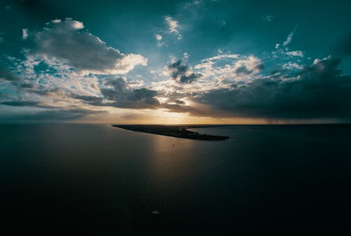 日没時の劇的な雲の下の穏やかな海