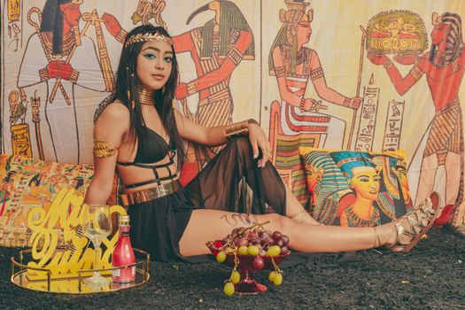 Model in Egyptian theme setting with jewelry and gold accessories.