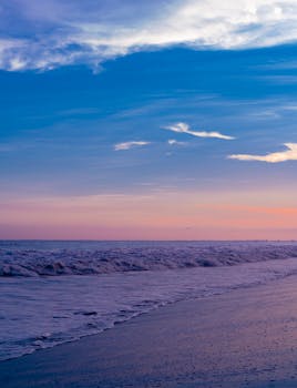 A tranquil beach at sunset with vibrant blue and orange skies, perfect for relaxing ambiance.